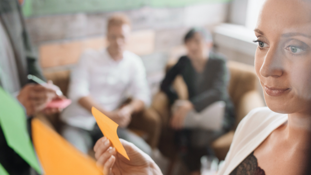 woman looking at orange post-it note