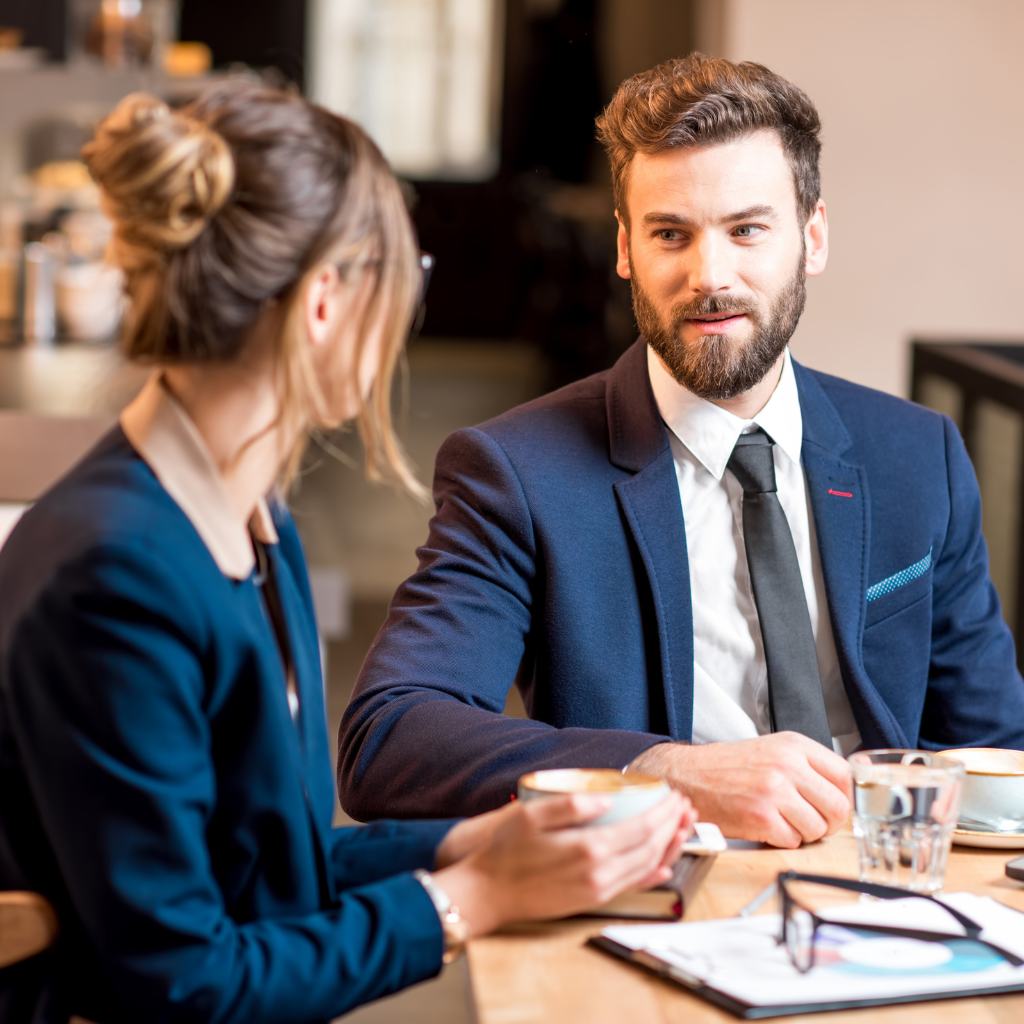 a man and a woman having a coffee in business attire at a training meeting
